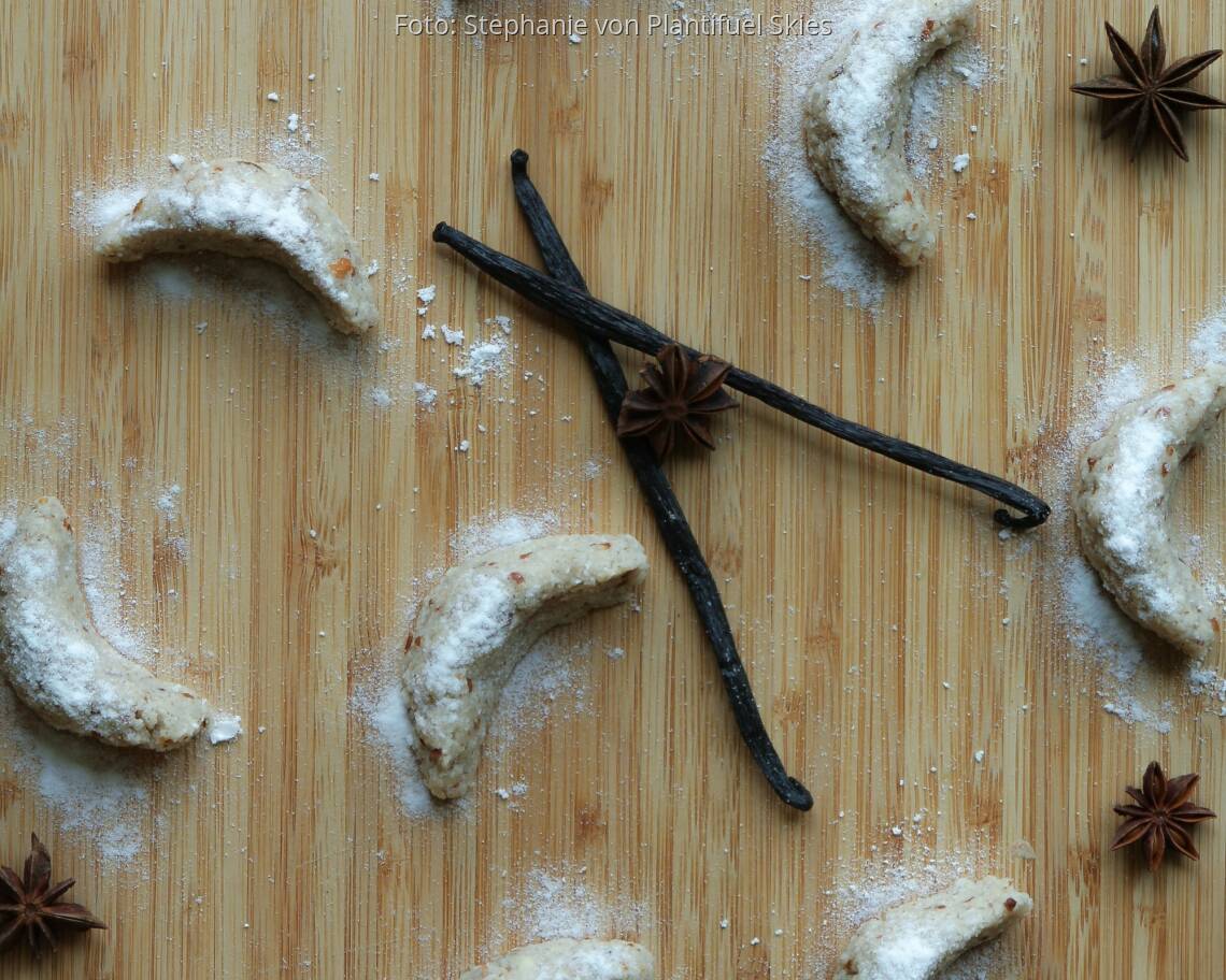 Rohe Vnaillekipferl auf Holzbrett mit Vanilleschote und Sternanis
