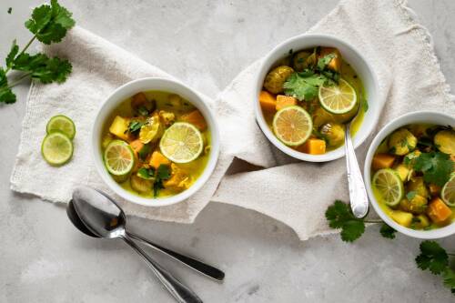 Rosenkohl-Steckrüben-Eintopf in Schüsseln vor hellem Hintergrund.