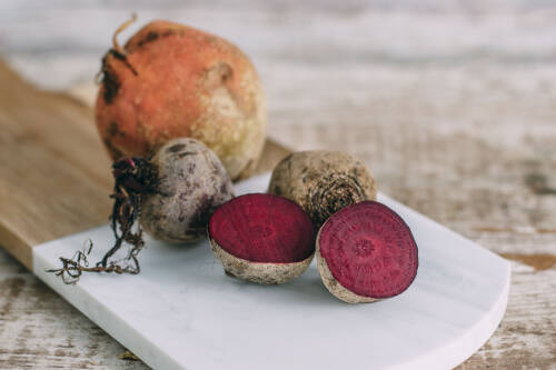Aufgeschnittene Rote Bete auf einer weißen Marmorplatte.