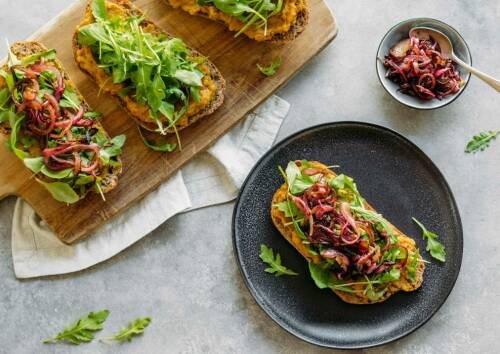 Ein leckeres Sandwich mit Linsencreme und Balsamico auf einem Teller.
