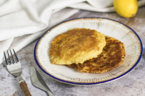 Selbst gemachte Kartoffelpuffer mit Sauerkraut auf einem weißen Teller.