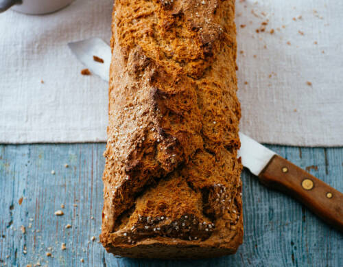 Vollkornbrot auf Messer vor hellem Hintergrund.