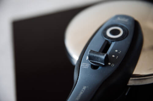 Schnellkochtopf vor dunklem Hintergrund.