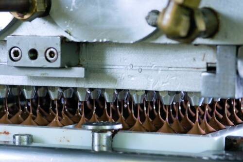 Schokalde wird von einer Maschine in Formen gegossen.