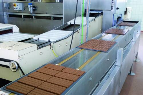 Fertige Schokoladentafeln auf einem Förderband.