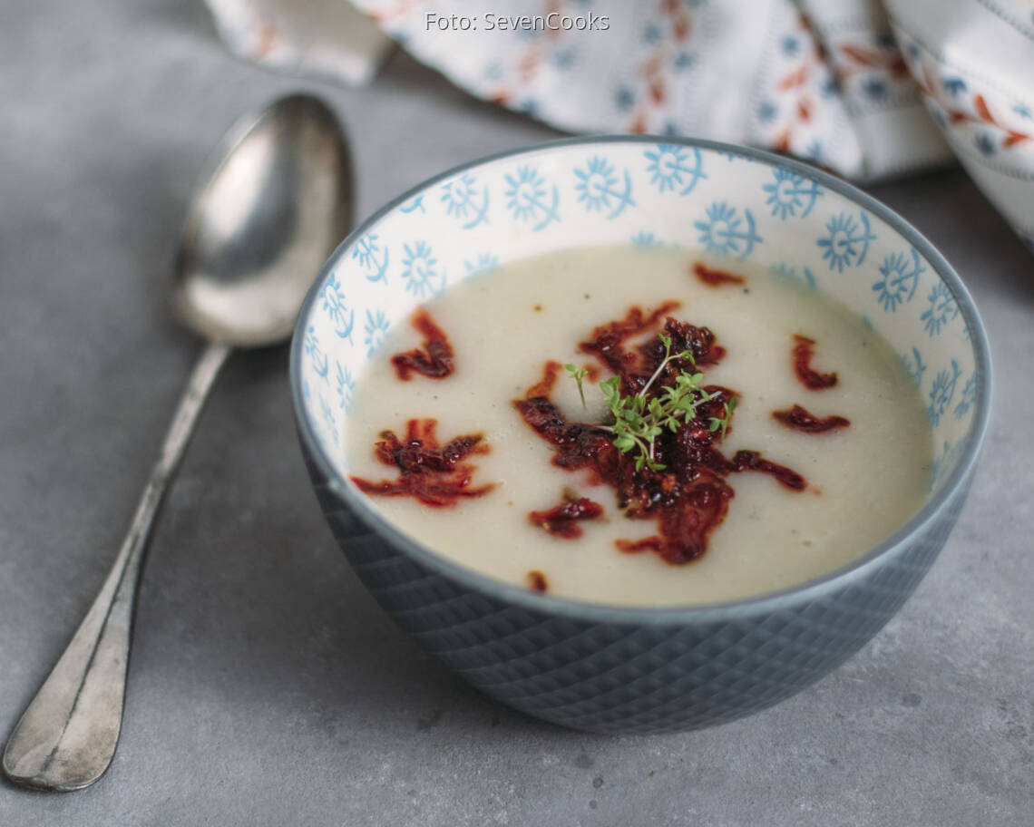 Blaue Schüssel mit Suppe, angerichtet mit Löffel und Rote Bete Einlage