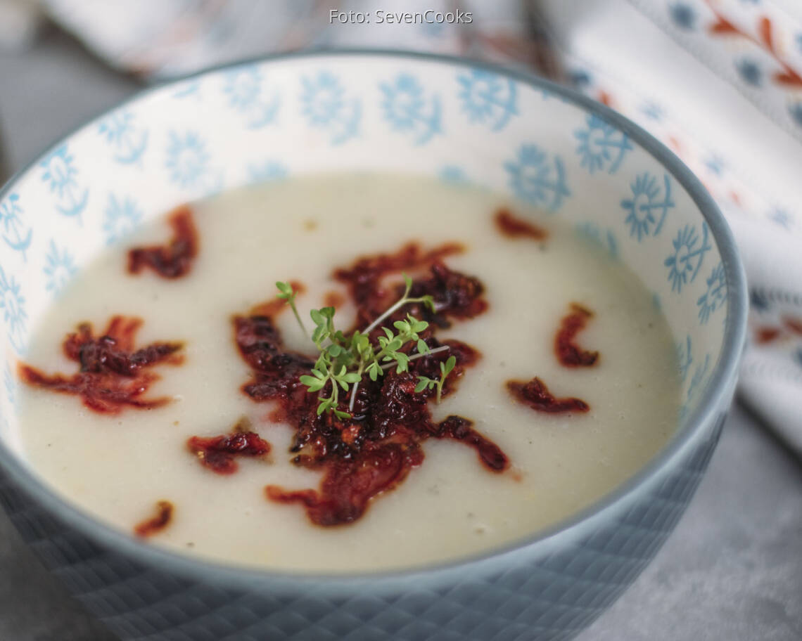 Blaue Schüssel mit Suppe, angerichtet mit Löffel und Rote Bete Einlage