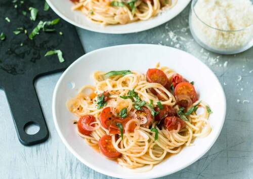 Ein Klassiker: Spaghetti mit Tomaten in leckerem Olivenöl und Knoblauch. Dazu gibt es Parmesan, von oben fotografiert.