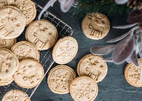 Selbstgemachter Spekulatius auf einem Gitter mit weihnachtlichen Motiven. Von oben fotografiert.