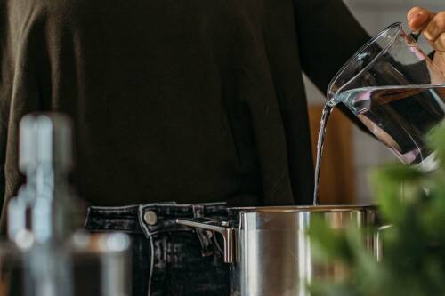 Wasser, das gerade in einen Kochtopf gegossen wird.