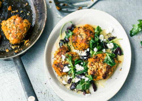 Herzhafte Süßkartoffelplätzchen mit Sonnenblumenkernen und Rucolabutter, von oben fotografiert.