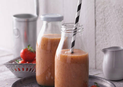 Smoothie in Glasflaschen und Strohhalm, von vorne fotografiert vor weißem Hintergrund