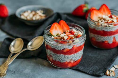 Sweet Earl Grey Frühstück in Gläsern mit Chiasamen vor dunklem Hintergrund.