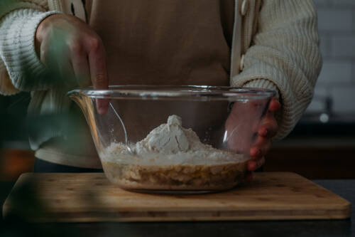 Backpulver, Wasser, Öl werden in einer Schüssel aus Glas vermengt.