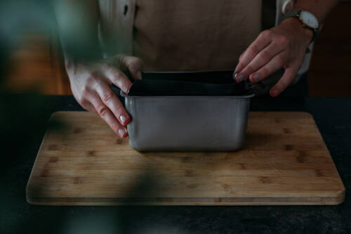 In eine Kastenform wird eine Folie eingelegt, die verhindert, dass das Brot beim Backen an der Form festklebt.
