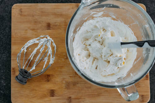 Frosting aus Margarine in Schüssel vor dunklem Hintergrund.