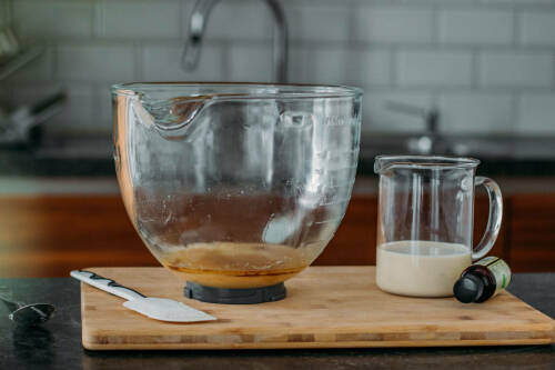 Öl in Schüssel mit Sojamilch vor dunklem Hintergrund.