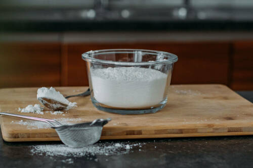 Mehl in Schüssel vor dunklem Hintergrund.