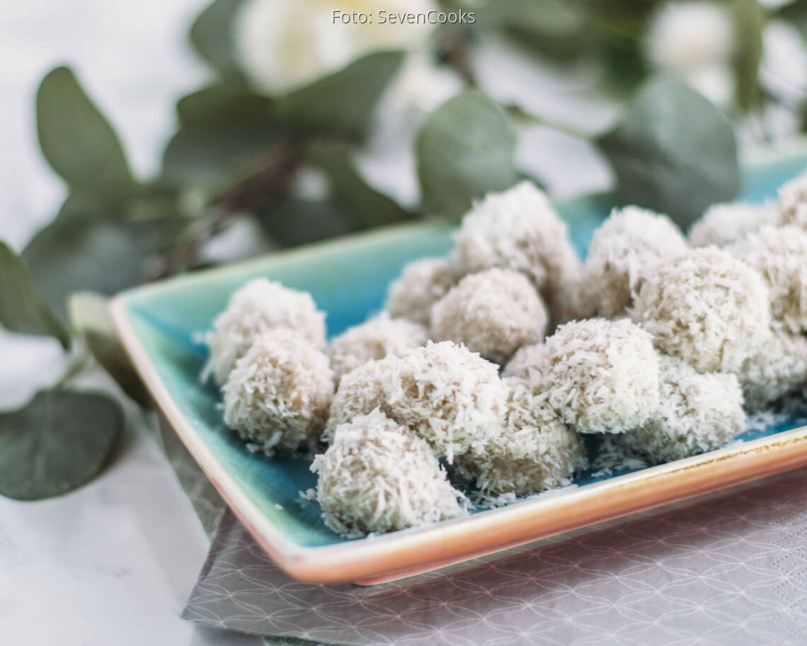 Vegane Raffaellos in Kokosraspeln auf blauer Platte