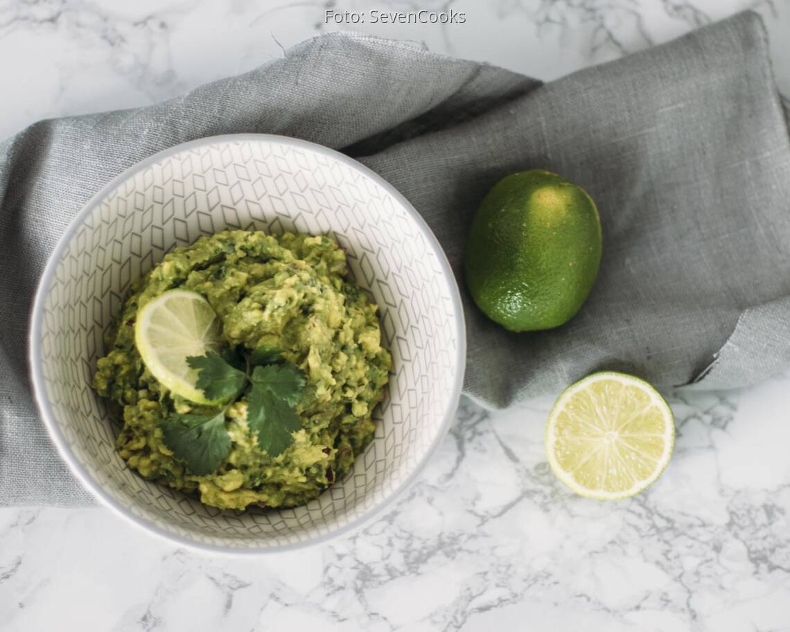 Veganes Rezept: Guacamole mit aufgeschnittener Limette in Schüssel angerichtet