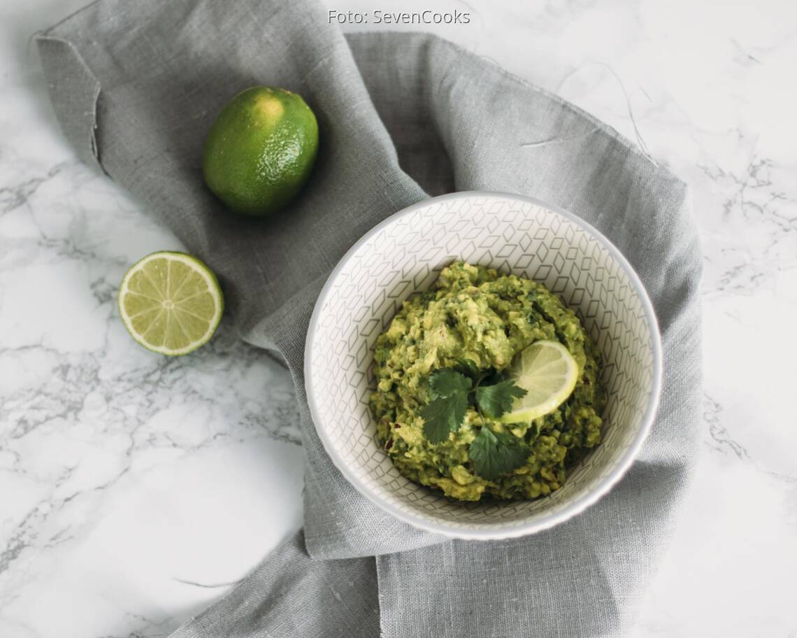 Veganes Rezept: Guacamole mit aufgeschnittener Limette in Schüssel angerichtet