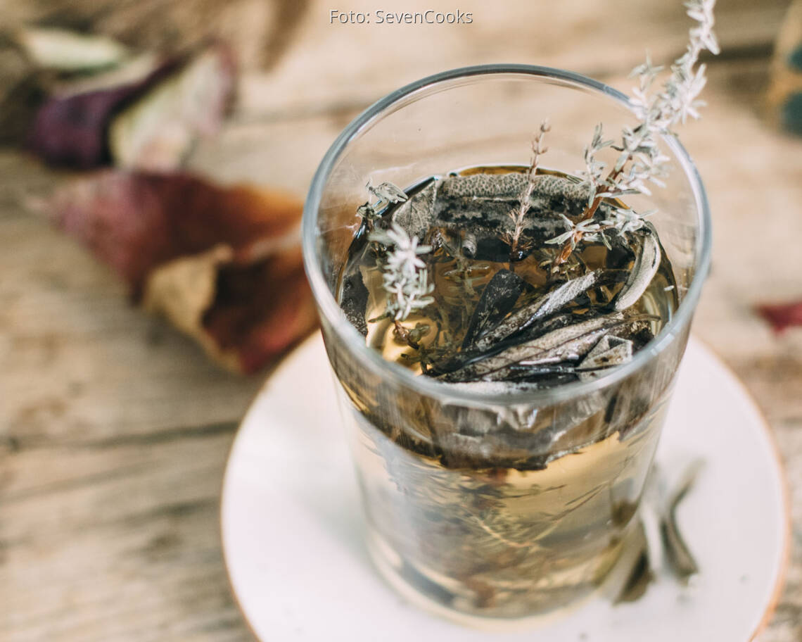 Thymian und Salbei Zweige in Teeglas auf Holztisch und Deko