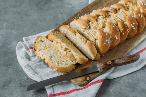 veganes rezept veganer hefezopf mit Hagelzucker aufgeschnitten auf einem Holzbrett