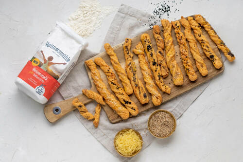 Selbst gebackene Käsestangen auf einem Holzbrett