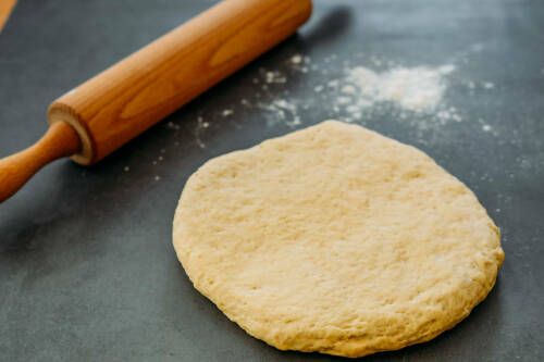 ausgerollter quark öl teig mit Nudelholz im Hintergrund