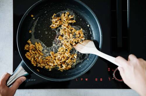 Walnüsse werden in heißem Zckerwasser umgerührt.