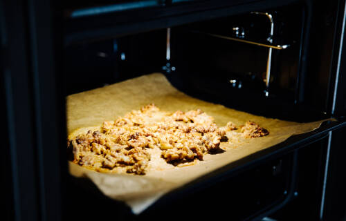 Ein Backblech im Ofen voller Walnüsse.