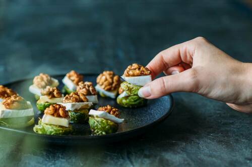 Rosenkohl bedeckt mit Käse und Walnüssen.