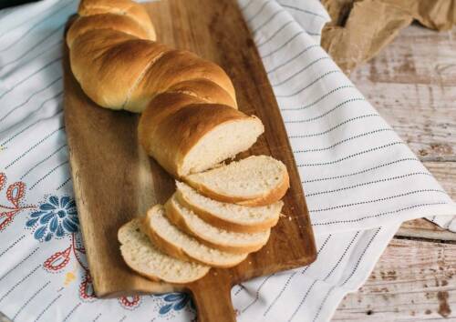 Lockeres Weißbrot aufgeschnitten auf einem Holzbrett und von oben fotografiert.