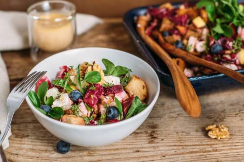 Winterlicher Brotsalat mit Rote Bete in Schüssel vor hellem Hintergrund.