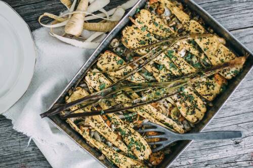 Ein Blech von oben mit verschiedenem Gemüse: Pastinaken mit grünen Kräutern bestreut, Karotten, Zwiebeln, Lauch