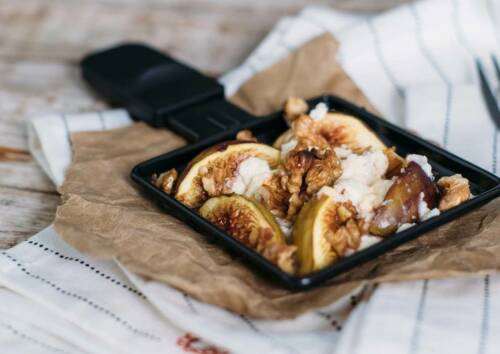 Raclette-Pfännchen mit Ziegenkäse, Feigen und Walnüssen. Von vorne fotografiert.