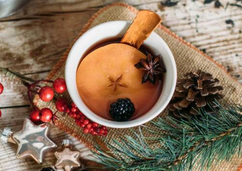Zuckerarmer Kinderpunsch in einer Tasse, daneben Tannenzapfen - und Zweige. Von oben fotografiert.
